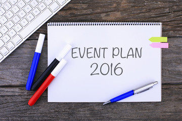 Notebook with EVENT PLAN 2016 Handwritten on wooden background 