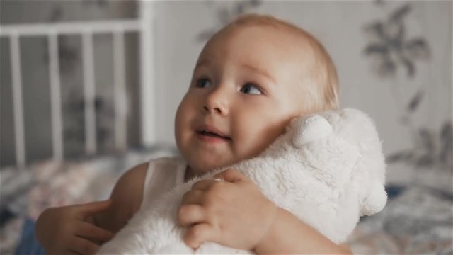 Adorable small baby girl hugs her toy
