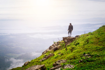 a man standing on the top of the mountain observing nature