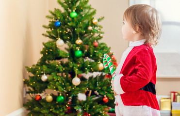 Toddler girl playing in front of the Christmas tree