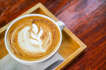 Latte Coffee art on the wooden table .