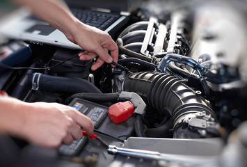 Hands of car mechanic with wrench in garage.