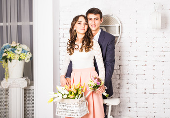 fashion photo of elegant loving couple posing at studio with classic interior near the bicycle