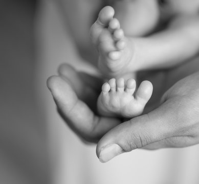tiny newborn feet in human palm