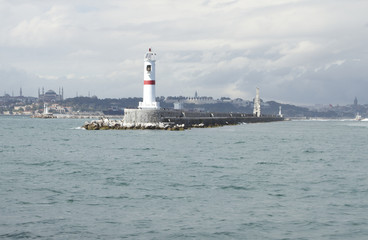 White light house in the sea near the city