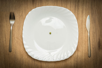 One green pea on white plate
