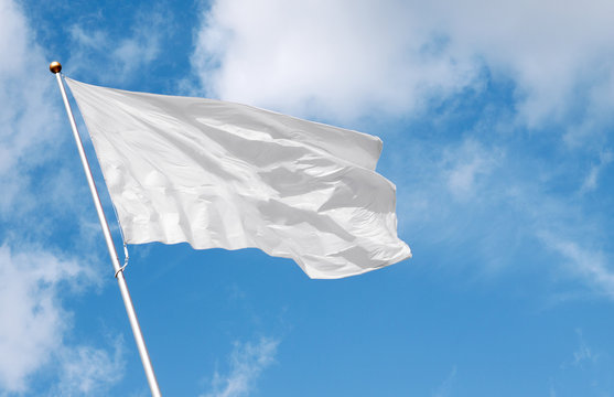 White blank flag waving in the wind against cloudy sky