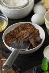 Grated chocolate with ingredients for cooking chocolate dessert