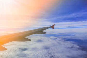 Fototapeta na wymiar Airplane flying above clouds at sunrise filter