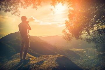 Man Traveler with photo camera outdoor Travel Lifestyle survival