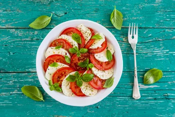 Poster Delicious caprese salad with ripe tomatoes and mozzarella cheese with fresh basil leaves. Italian food.  © iMarzi