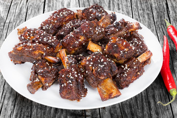 Chinese spicy Spare Ribs on white dish sprinkled with sesame