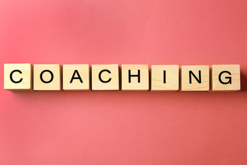 Coaching concept. Wooden cubes on pink background