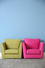 Fototapeta na wymiar Two armchairs on blue wall background