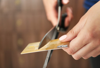Female hands cutting credit card with scissors