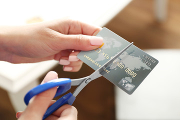 Female hands cutting credit card with scissors