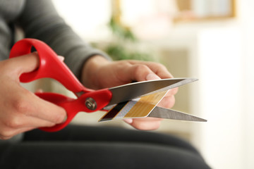 Female hands cutting credit card with scissors