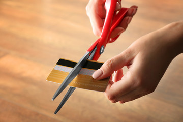 Female hands cutting credit card with scissors