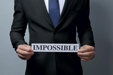 Businessman holding paper with impossible word