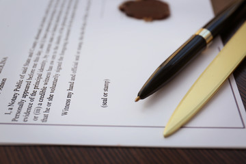 Fototapeta premium Pen, office knife and old notarial wax seal on document, closeup