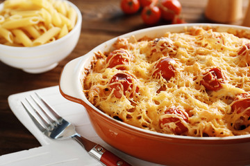 Delicious pasta Al Forno in ceramic bowl on wooden table