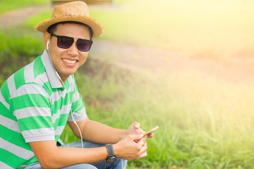 Side portrait of young asian guy sitting on chair and listening