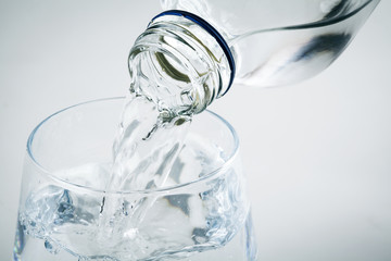Pouring water on glass on white background