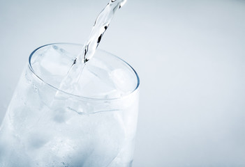 Filling a glass with water on white background