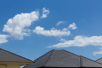 Fototapeta na wymiar black tile roof on house with clear blue sky and cloud