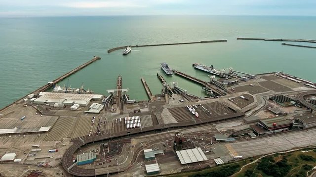 Aerial view Dover international shipping container harbour port, cargo ships loaded with containers. Helicopter shot flying by boats and vehicles 4K UHD