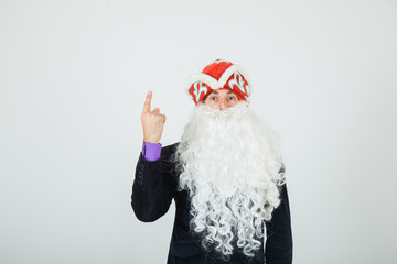 Santa in black suit pointing up.  Copy space.  Copy space for text. Christmas New Year preparation.