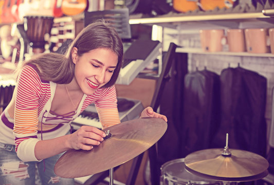Happy girl choosing drums and accessories