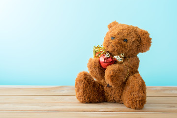 teddy bear hug christmas bubble gift on wood table.