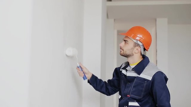 man decorating room. painting wall with paint roller
