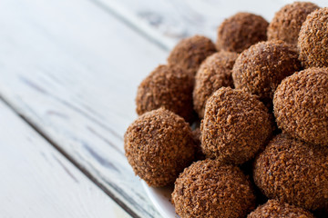 Pile of brown candies. Desserts with crumbs. Fresh and tasty chocolate balls. Biscuits and cocoa.