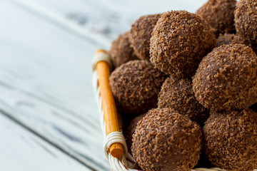 Dark sweets with crumbs. Pile of candies in basket. Recipe of chocolate rum balls. Delicious russian dessert.