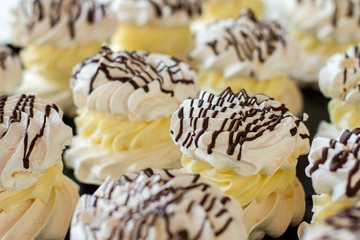 Meringues with cream. Small decorated sweets. Desserts in french cafe. Product made of egg whites.