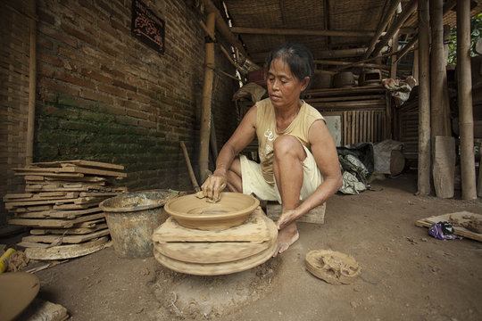Mature woman making a bowl on potter's wheel, Jember, East Java, Indonesia