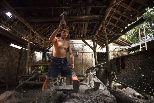 Mature man making a sword