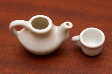 White teapot and white cup on a wooden background