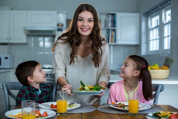 Mother serving breakfast to their children