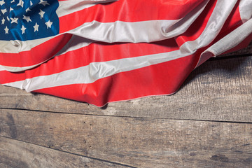 Fototapeta na wymiar An American Flag Lying on an aged, weathered rustic wooden background