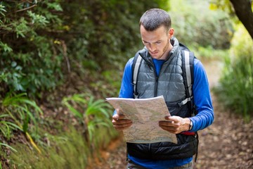 Fototapeta premium Male hiker looking at map