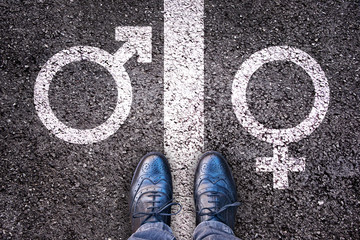 Legs with male female gender symbols on asphalt, gender identity choice, queer and transgender concept - obrazy, fototapety, plakaty
