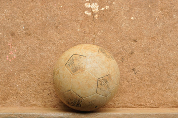 Old football on grunge cement floor