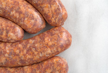 Bratwurst links on a marble cutting board.