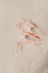 Pink ballet pointe shoes and tutu on white wood background