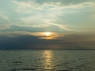 Obraz premium Sunset or sunrise over the ocean with some ship near the peer.