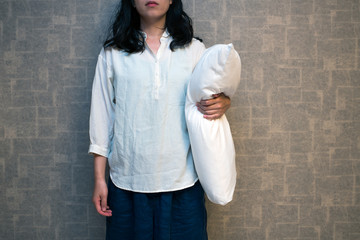 まくらを持つ女性
