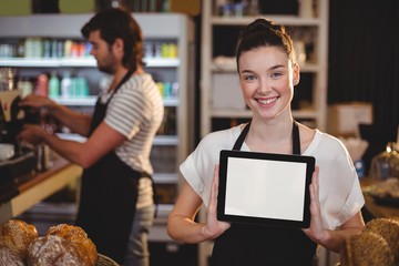 Smiling waitress showing digital tablet